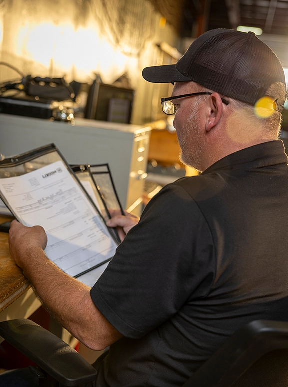 a mechanic looking at paperwork at a desk area