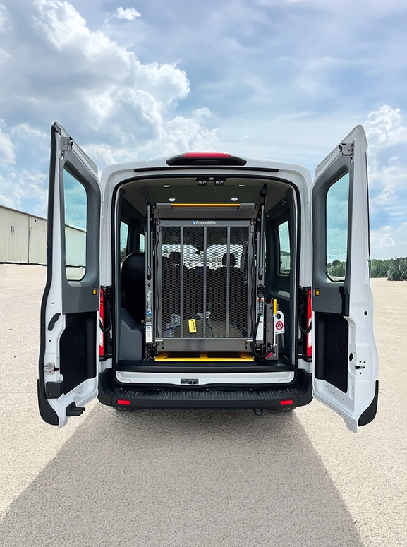 white wheelchair van parked in a large parking lot on a sunny day
